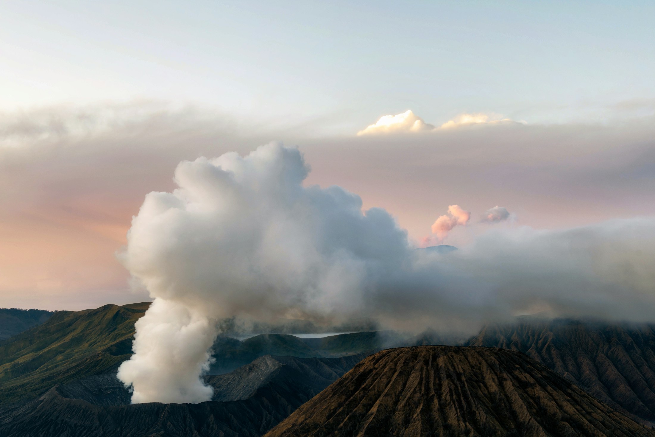 Kabut pagi menyelimuti lanskap Bromo dan pegunungan di kejauhan